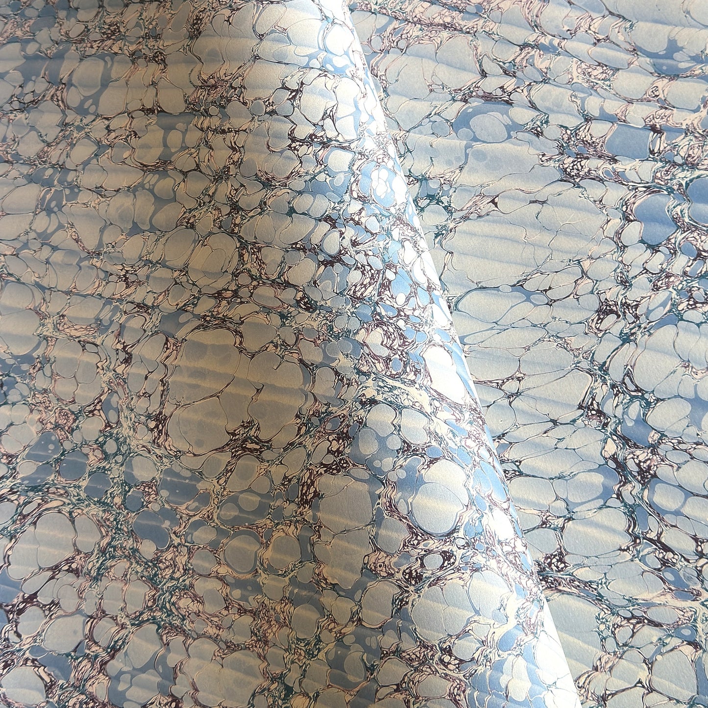 sheet of printed marbled wrapping paper by Jemma Lewis, stone effect in tones of pale blue