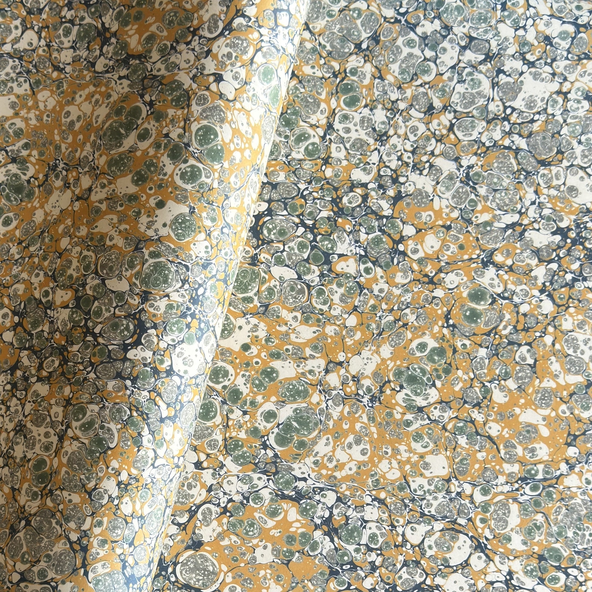 Printed marbled wrapping paper by Jemma Lewis Marbling. Marbled paper in soft greens, teal and yellow