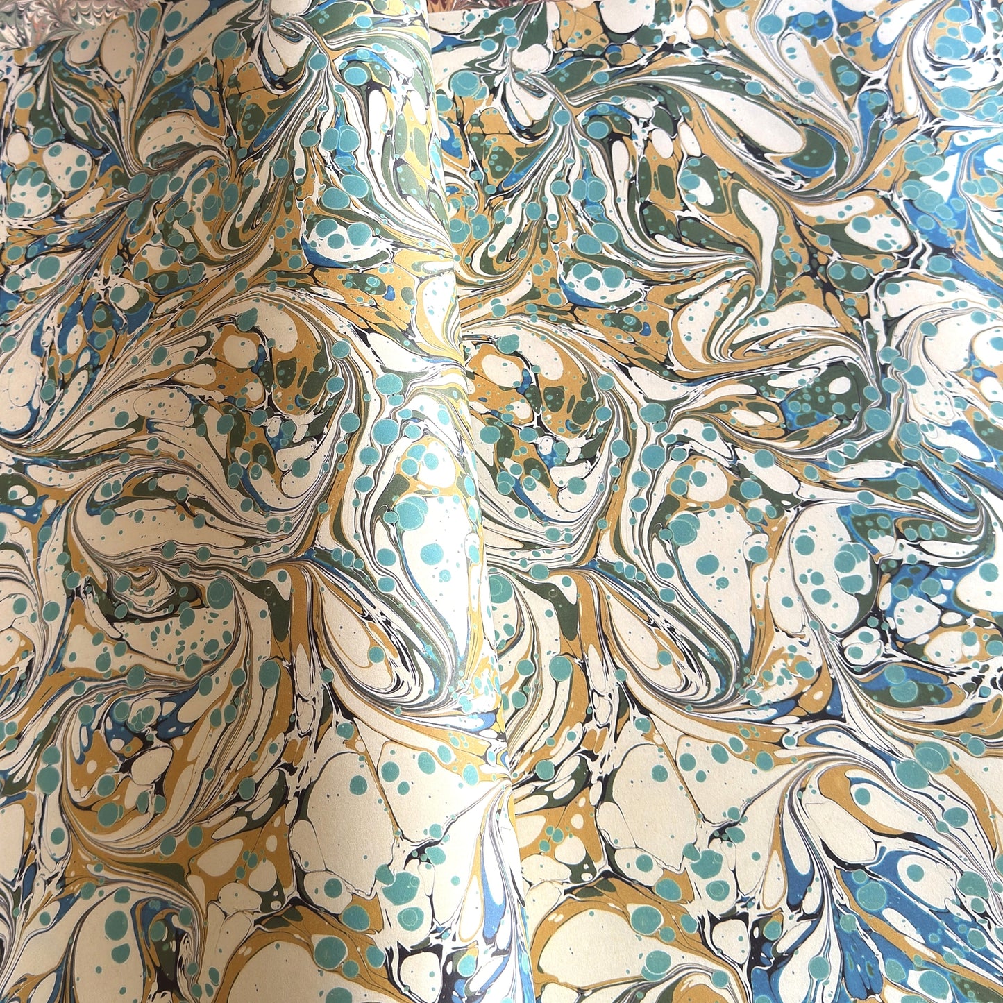 printed marbled wrapping paper with marbled pattern in aqua, blue, sand and cream.