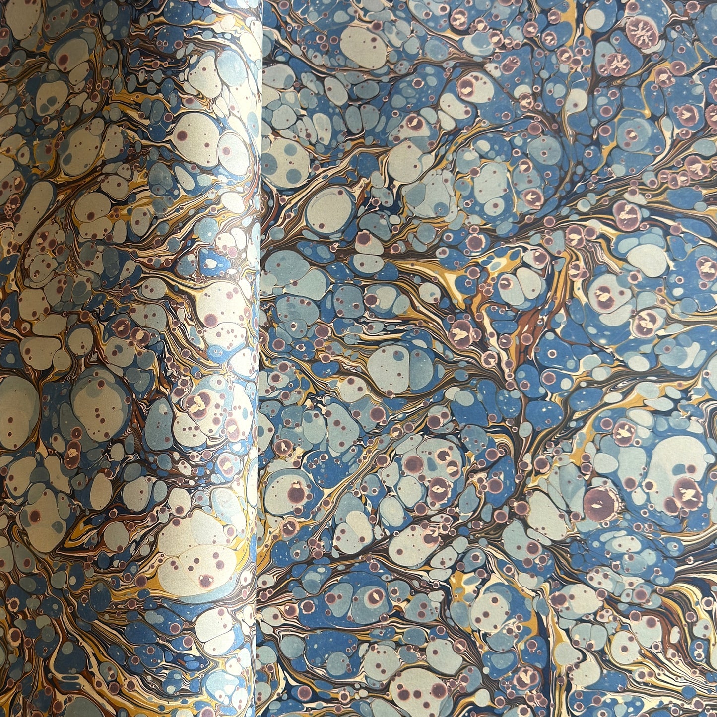 printed marbled wrapping paper by Jemma Lewis with a marbled pattern in blue, yellow, brown and cream