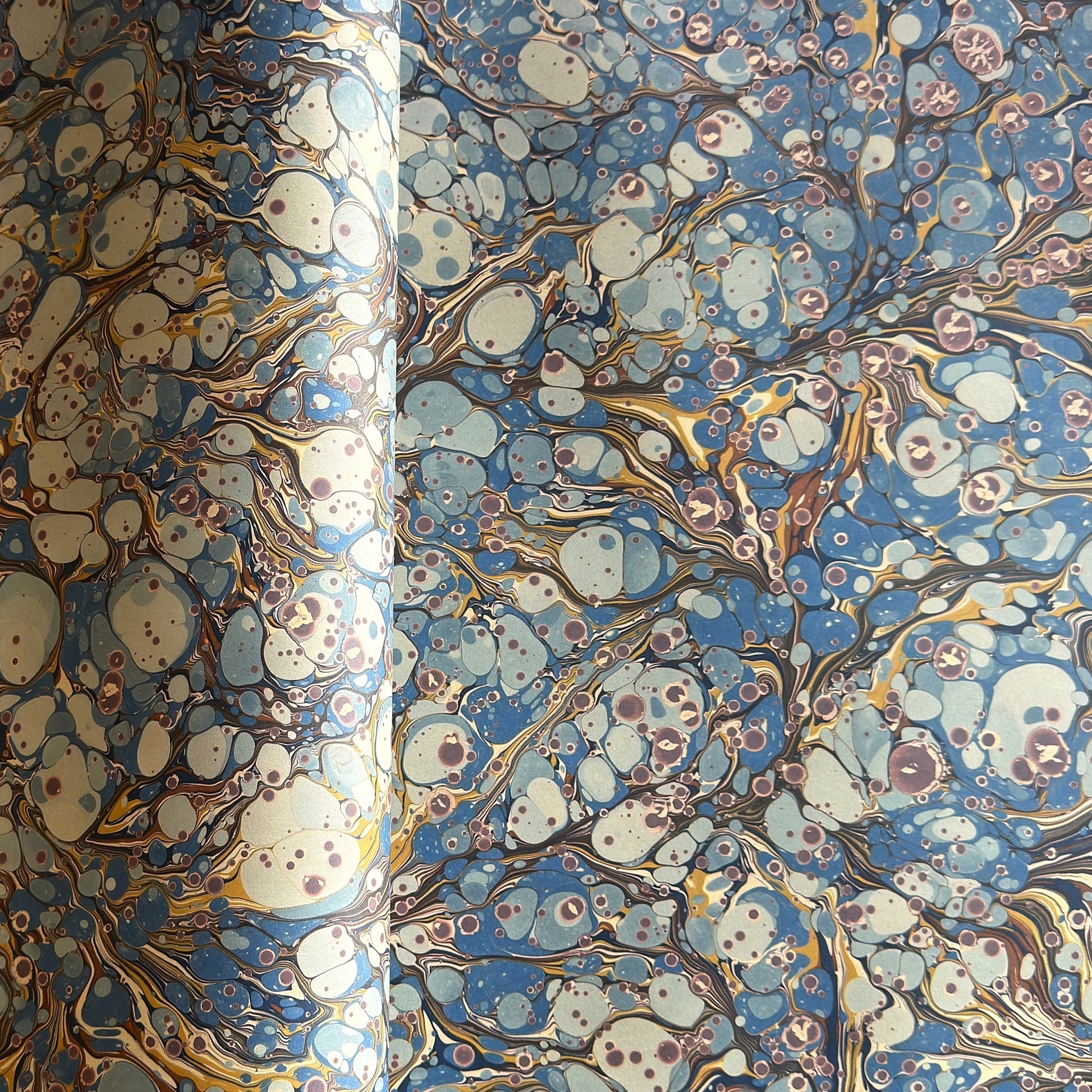printed marbled wrapping paper by Jemma Lewis with a marbled pattern in blue, yellow, brown and cream
