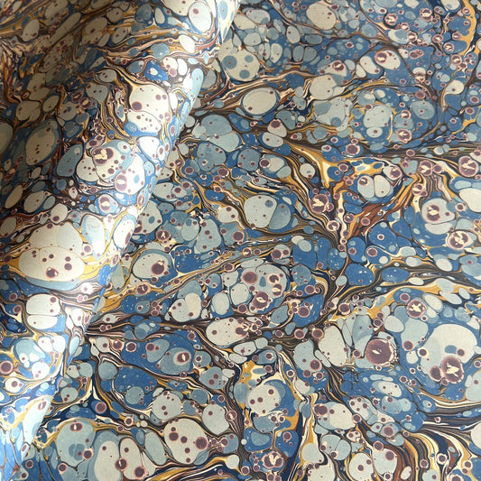 printed marbled wrapping paper by Jemma Lewis with a marbled pattern in blue, yellow, brown and cream