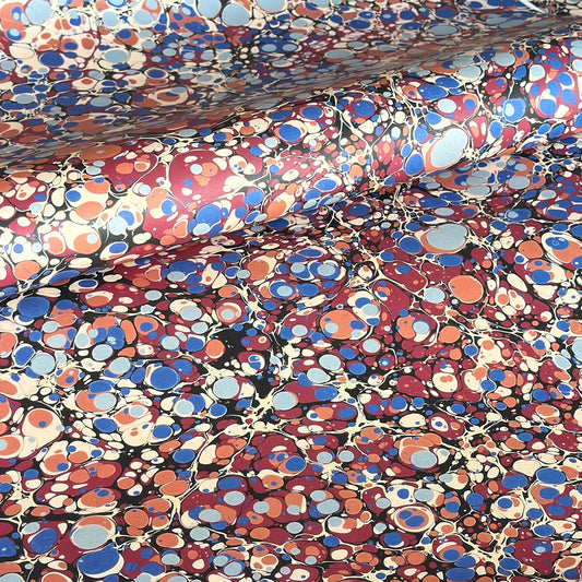 Printed marbled wrapping paper by Jemma Lewis Marbling. Marbled paper in bold red, blue and orange