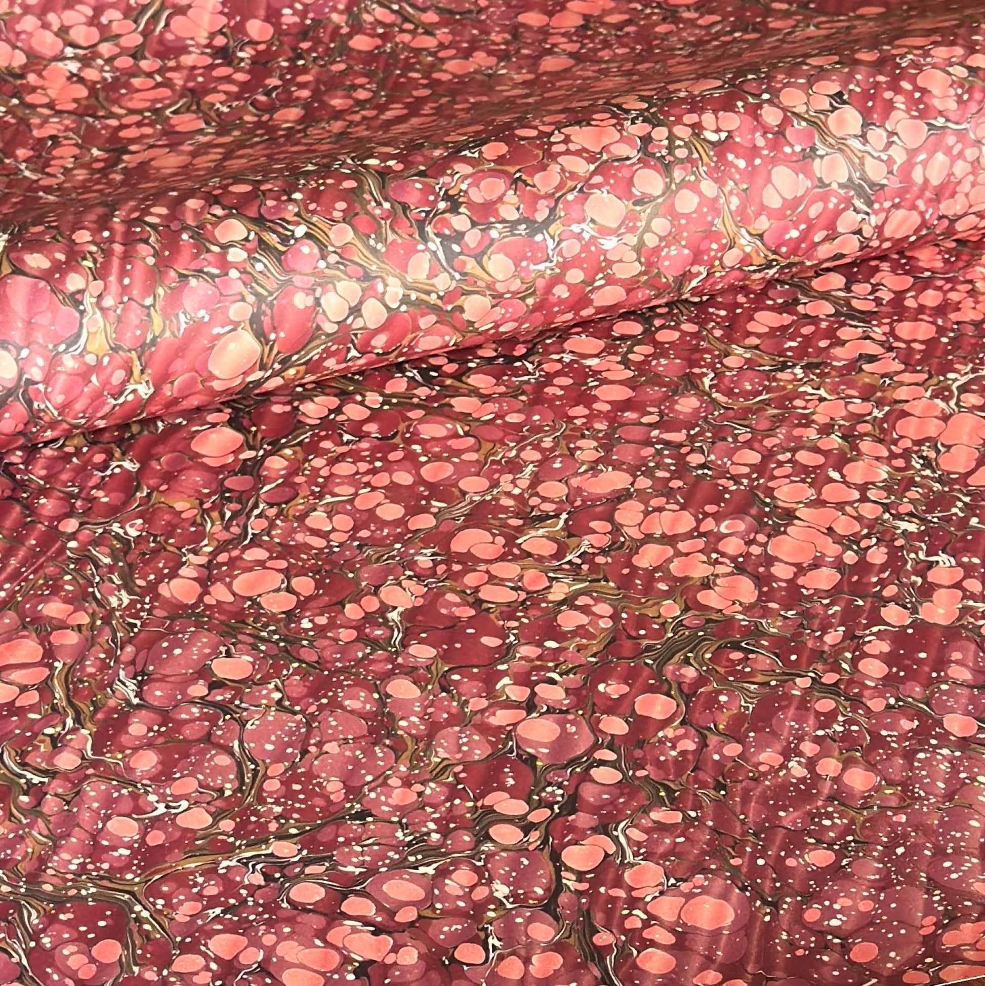 Printed marbled wrapping paper by Jemma Lewis Marbling. Marbled paper in deep burgundy, pinks and brown