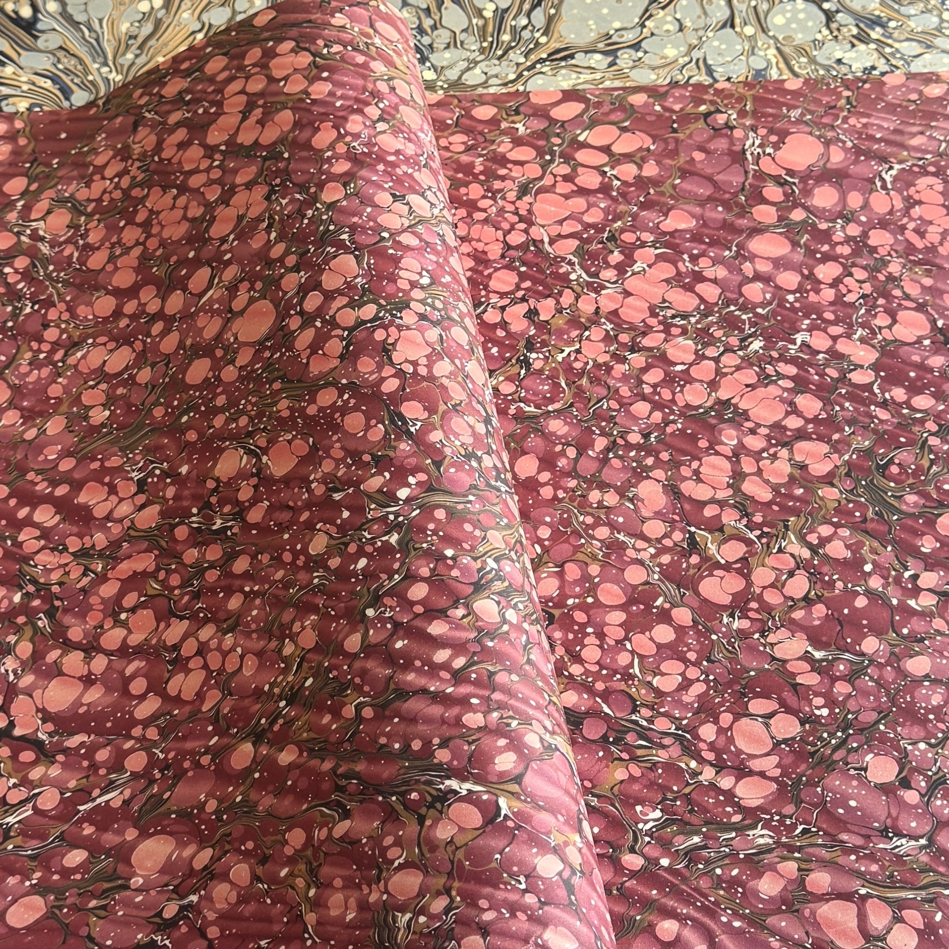 Printed marbled wrapping paper by Jemma Lewis Marbling. Marbled paper in deep burgundy, pinks and brown