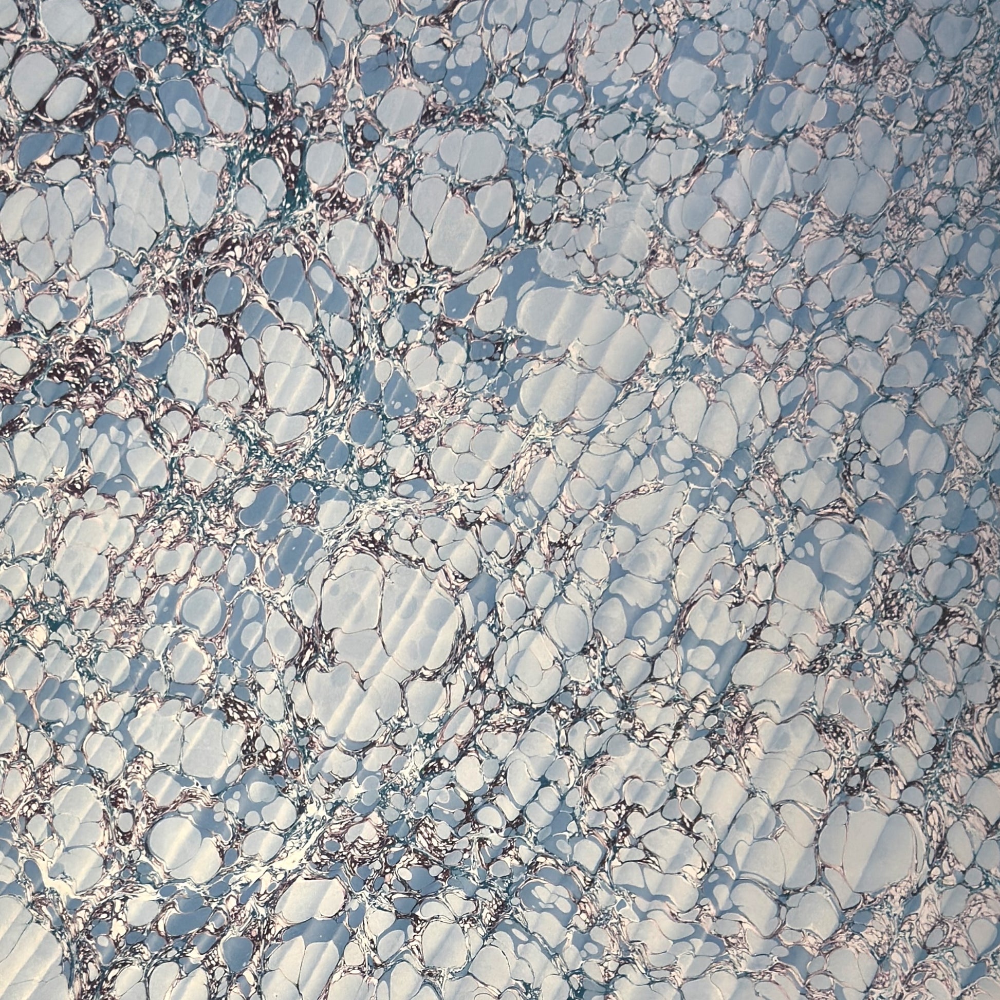 sheet of printed marbled wrapping paper by Jemma Lewis, stone effect in tones of pale blue