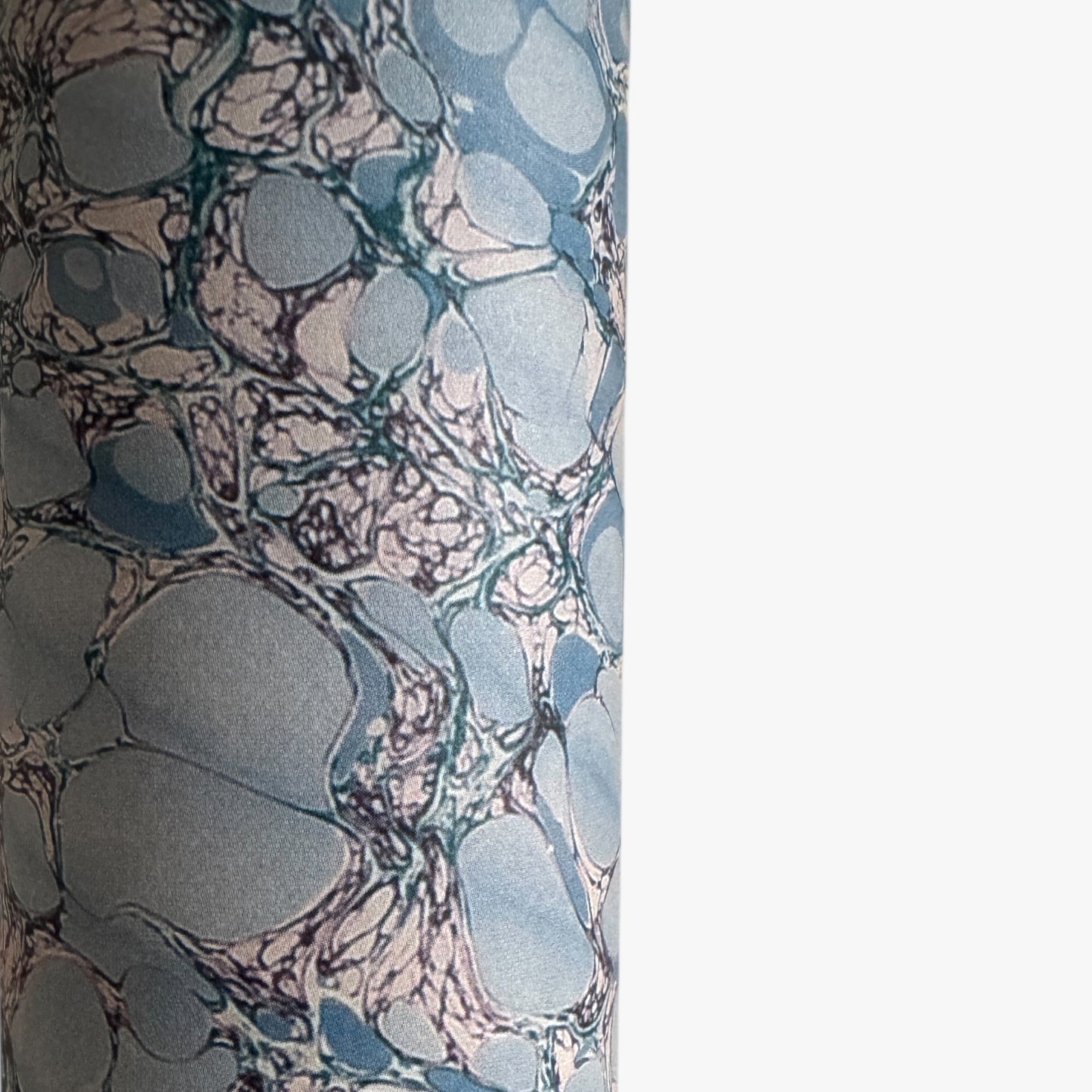 sheet of printed marbled wrapping paper by Jemma Lewis, stone effect in tones of pale blue. Close up