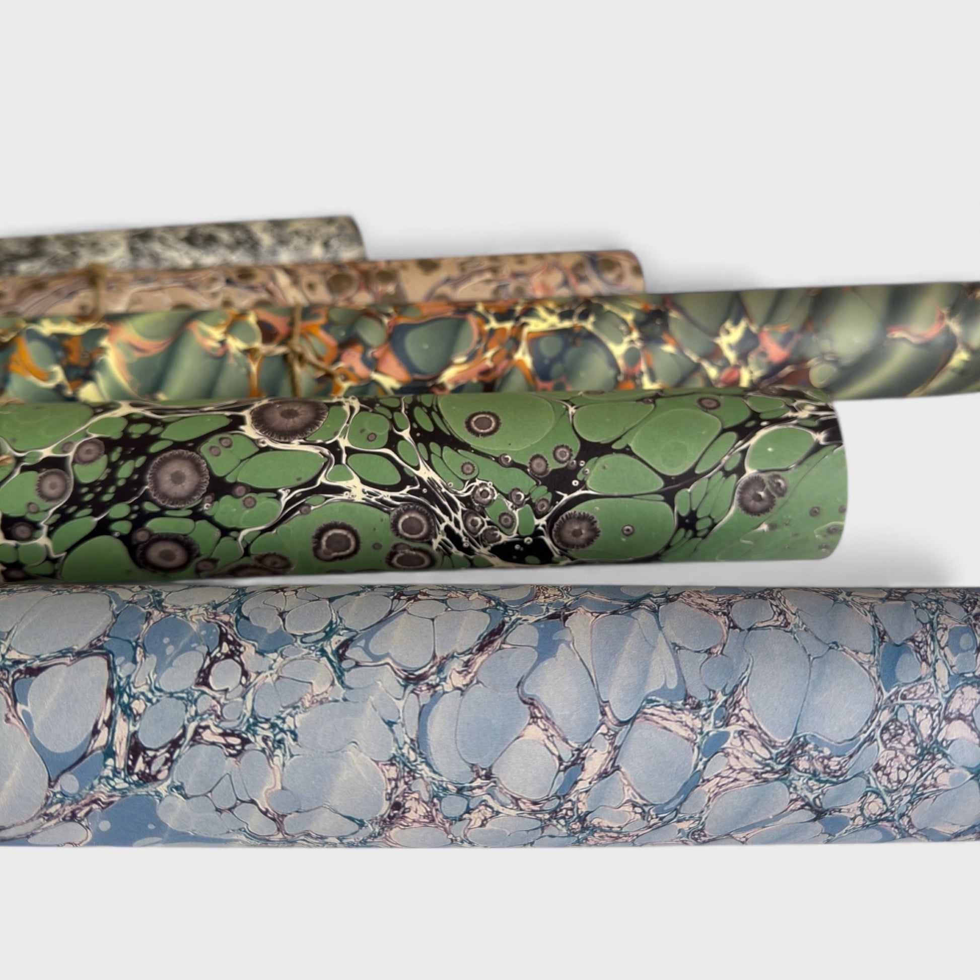 sheet of printed marbled wrapping paper by Jemma Lewis, stone effect in tones of pale blue. Rolled