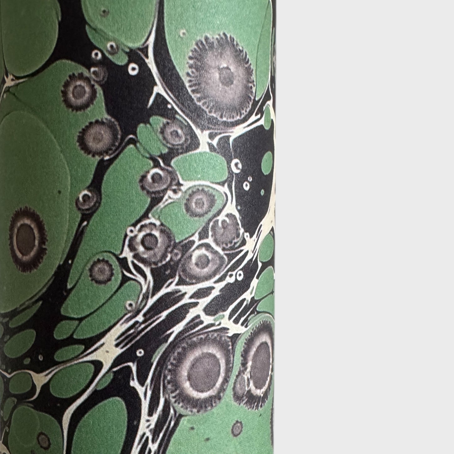 sheet of printed marbled wrapping paper by Jemma Lewis, stone effect in green and grey. Close up