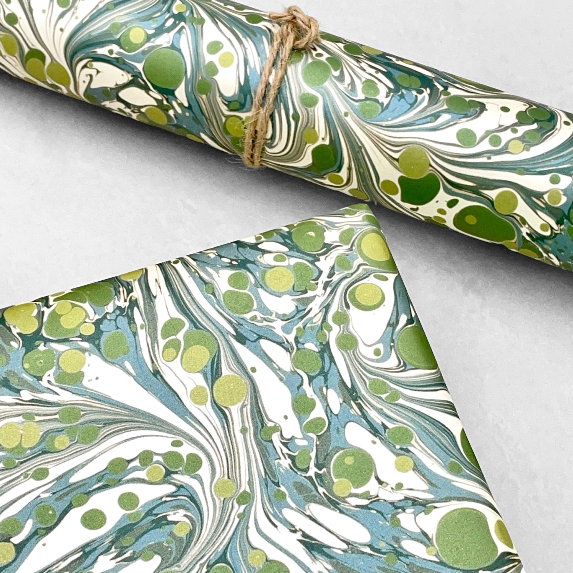Printed marbled wrapping paper by Jemma Lewis Marbling. Marbled paper with a shimmery base paper and marbled pattern in green, lime and white