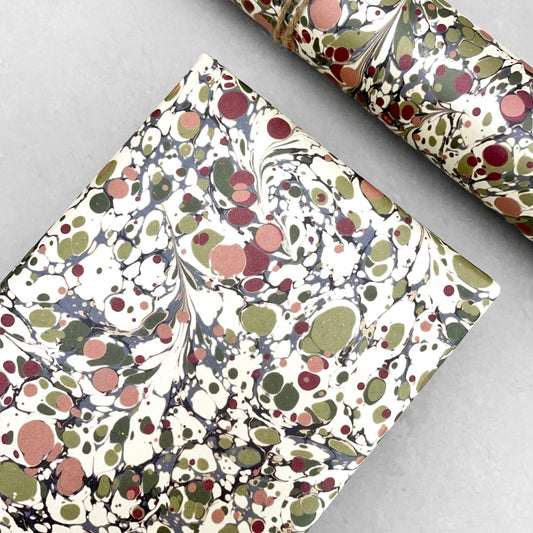 Printed marbled wrapping paper by Jemma Lewis Marbling. Marbled paper with a shimmery base paper and marbled pattern in burgundy, green and white