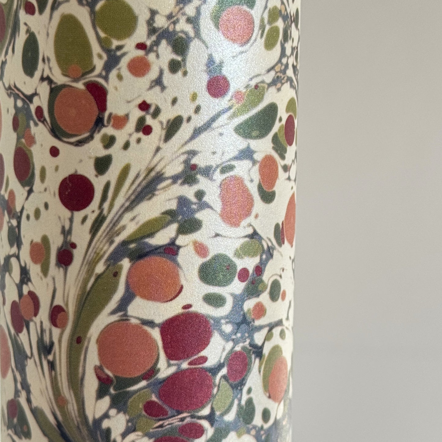 Printed marbled wrapping paper by Jemma Lewis Marbling. Marbled paper with a shimmery base paper and marbled pattern in burgundy, green and white. 