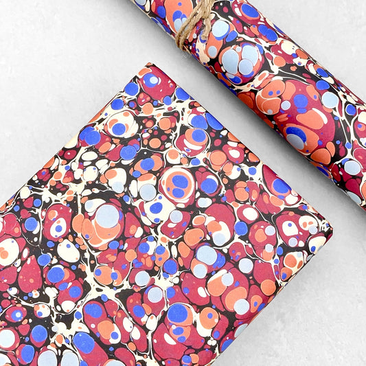 Printed marbled wrapping paper by Jemma Lewis Marbling. Marbled paper in bold red, blue and orange