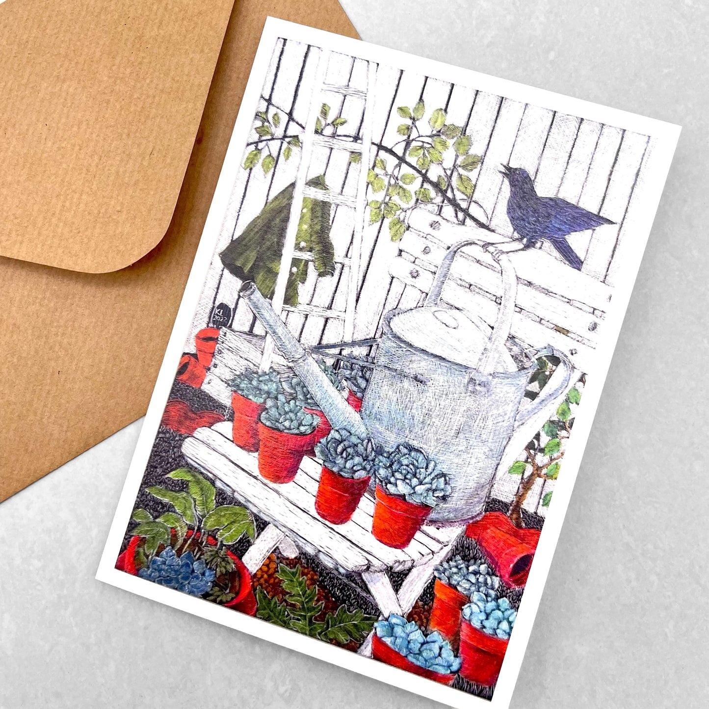 greetings card showing a drawing of a garden chair with a watering can, plants and a bird by John Austin Publishing