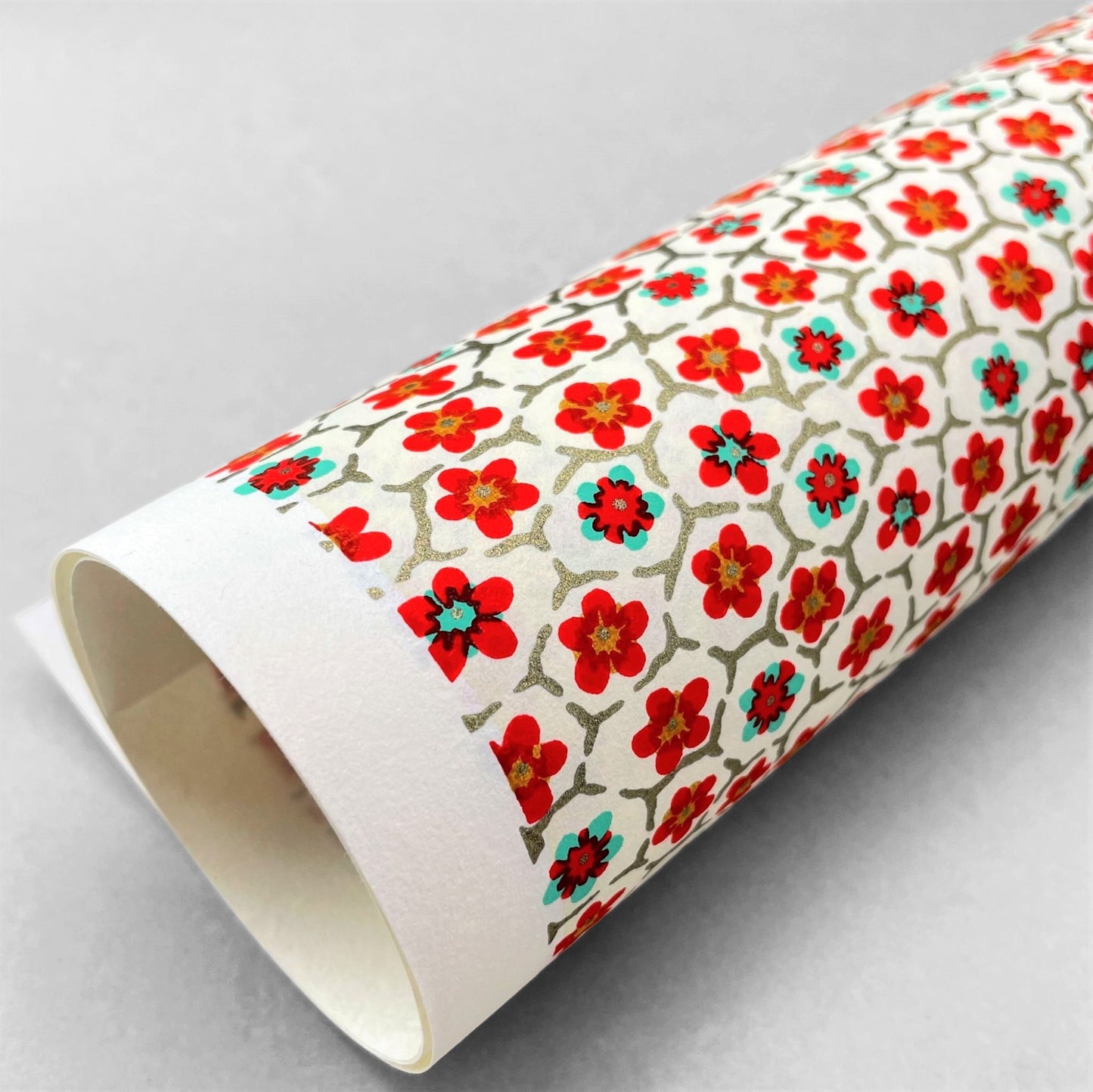 japanese silk-screen handmade paper, chiyogami, with red and aqua plum flowers repeat pattern