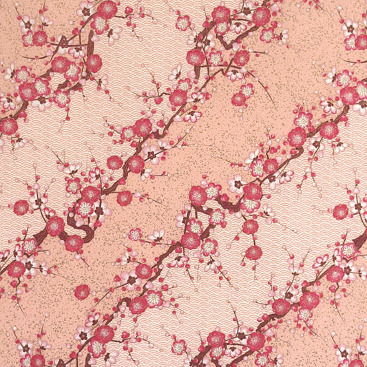 Diagonal branches of pink plum (ume) blossom on a light pink background with gold accents. Japanese chiyogami paper