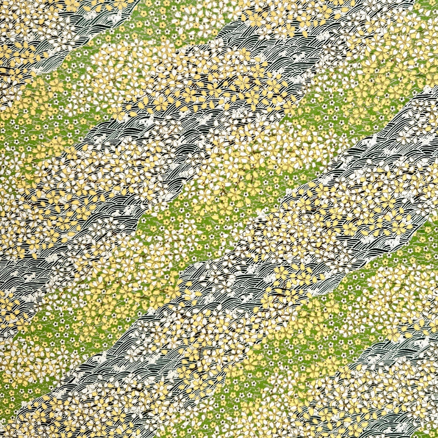 Japanese silkscreen chiyogami paper with a pattern of dark green rivers and grass green banks with an abundance of little flowers in white and yellow
