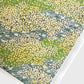 Japanese silkscreen chiyogami paper with a pattern of dark green rivers and grass green banks with an abundance of little flowers in white and yellow
