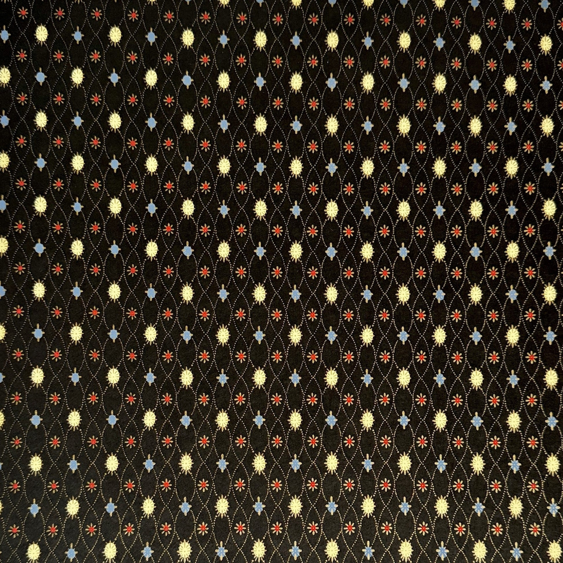 Japanese silkscreen chiyogami paper with a pattern of small repeat motifs in red, blue, lemon and gold on a black background