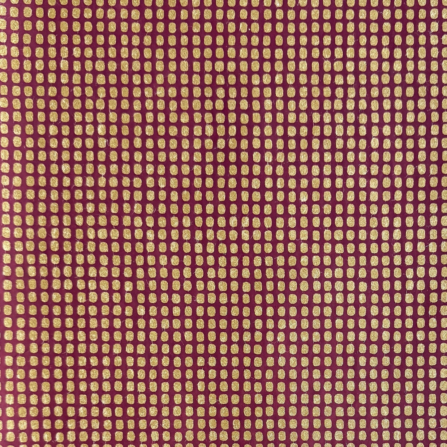 a sheet of Japanese chiyogami paper in rich claret red with a repeat pattern of gold rounded rectangles