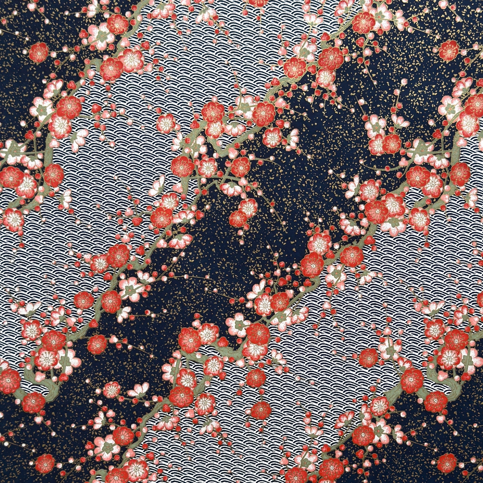 Diagonal branches of rich pink plum (ume) blossom on a midnight blue background with gold accents. Japanese chiyogami paper
