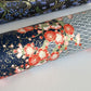 Diagonal branches of rich pink plum (ume) blossom on a midnight blue background with gold accents. Japanese chiyogami paper