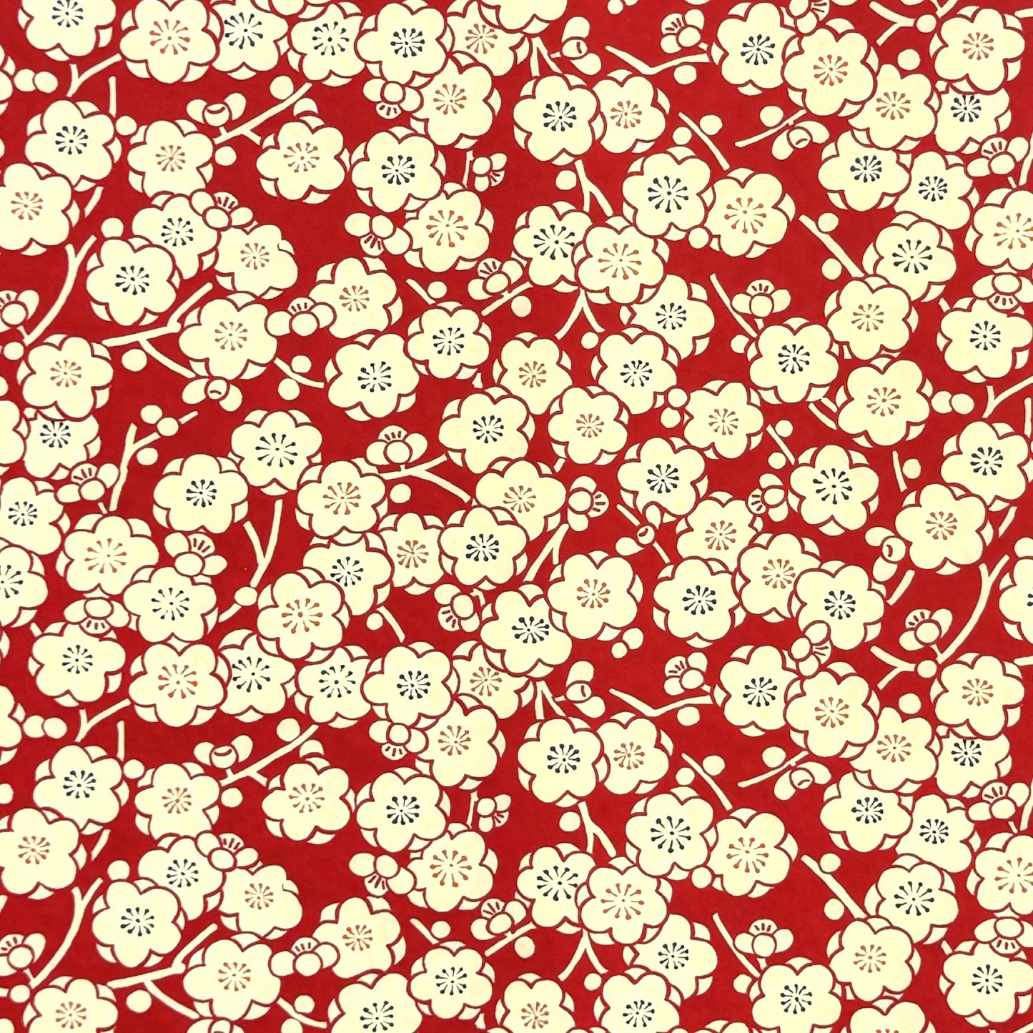 a sheet of chiyogami paper with a modern design of plum blossom in red and cream