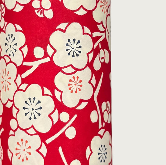 a sheet of chiyogami paper with a modern design of plum blossom in red and cream