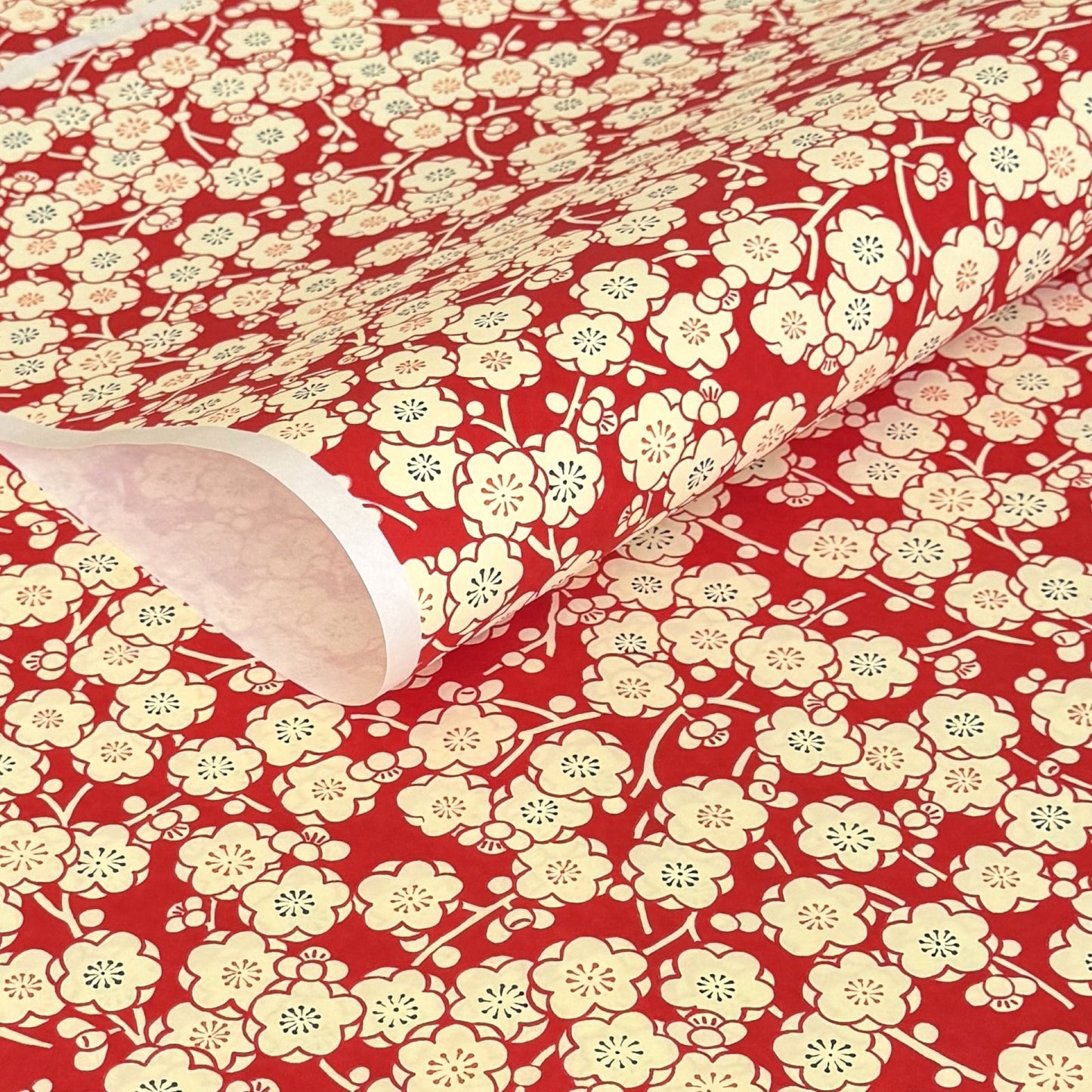 a sheet of chiyogami paper with a modern design of plum blossom in red and cream