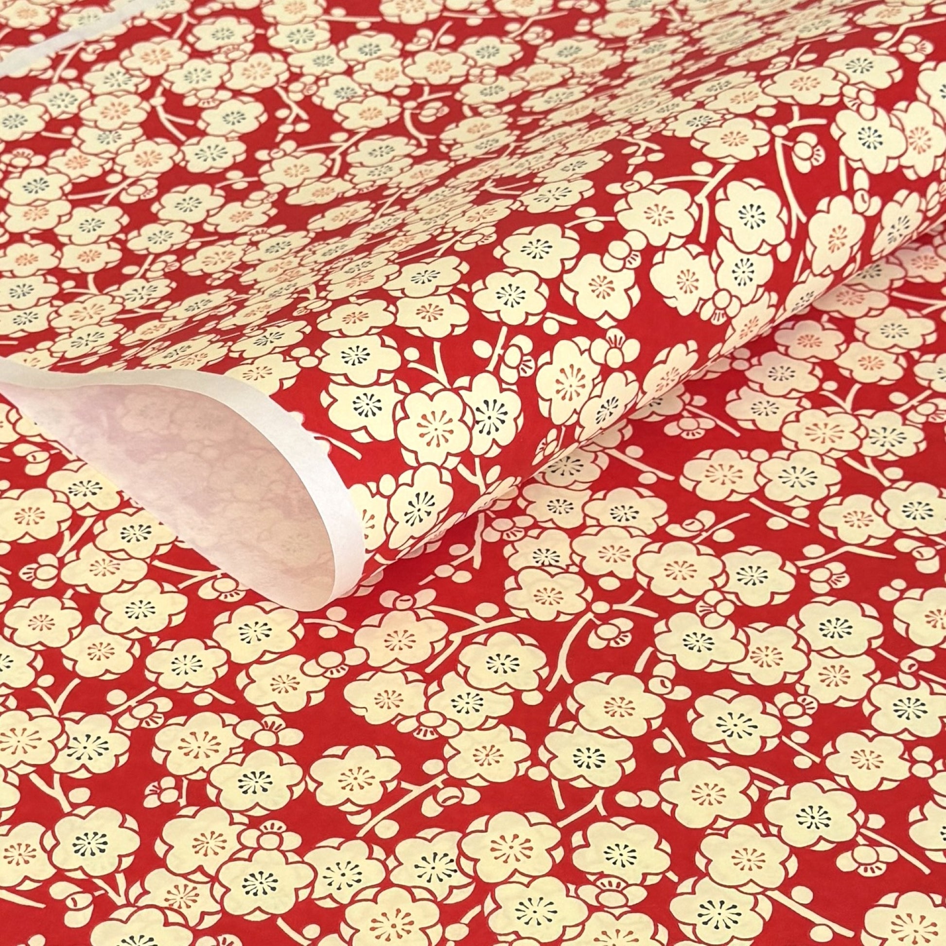 a sheet of chiyogami paper with a modern design of plum blossom in red and cream