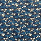 a sheet of Japanese chiyogami yuzen paper with a traditional pattern of white cranes flying with a deep blue background of patterned clouds