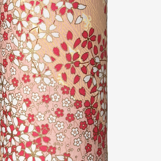 a sheet of Japanese chiyogami paper with a small floral pattern of sakura blossom in shades of pink and white