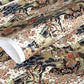 A sheet of Chiyogami paper with a traditional Japanese pattern of a detailed hillside in blue, red, bronze and black. 