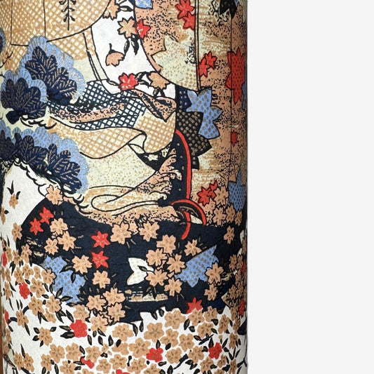 A sheet of Chiyogami paper with a traditional Japanese pattern of a detailed hillside in blue, red, bronze and black. 