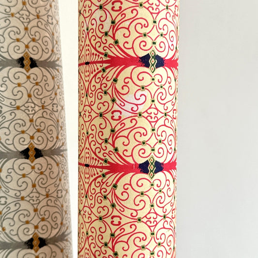 Japanese silkscreen chiyogami paper with a intricate filigree trellis design in pink with gold accent, rolled & close up