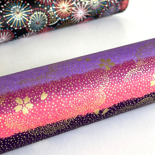 japanese chiyogami paper in stripes of pink, lilac and purple with gold clouds and flowers. Rolled