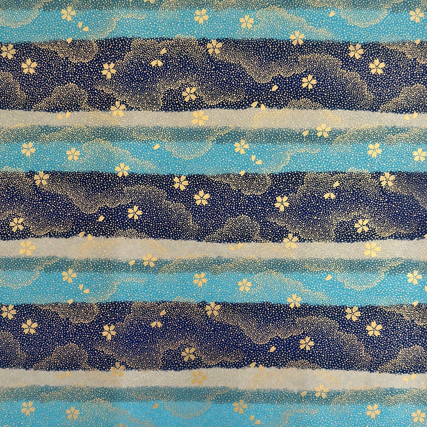 japanese chiyogami paper in stripes of blue, turquoise and grey with gold clouds and flowers