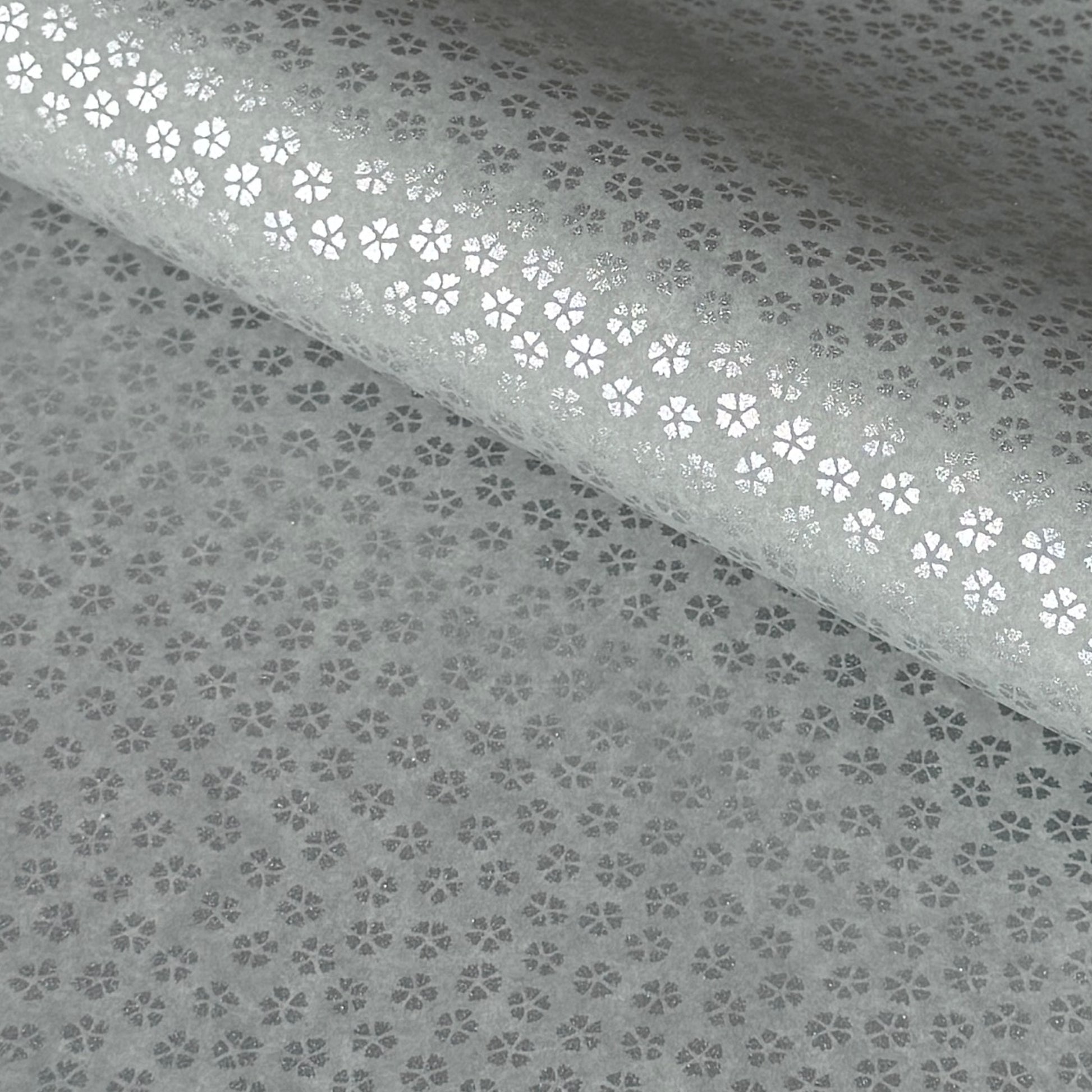 a sheet of chiyogami paper with light grey background and little silver stylised cherry blossom flowers in silver 