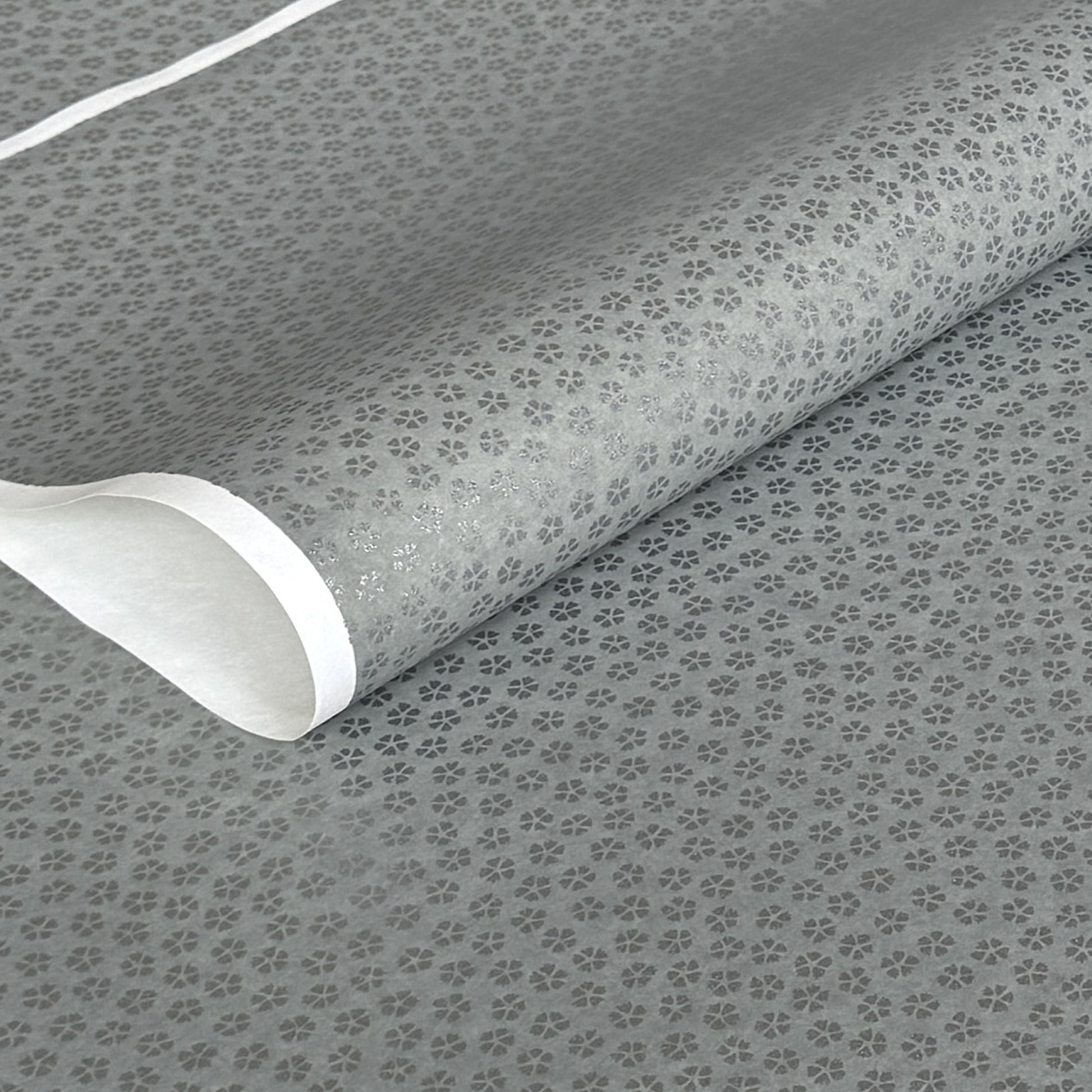 a sheet of chiyogami paper with light grey background and little silver stylised cherry blossom flowers in silver 