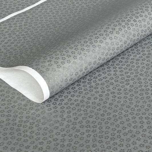 a sheet of chiyogami paper with light grey background and little silver stylised cherry blossom flowers in silver 