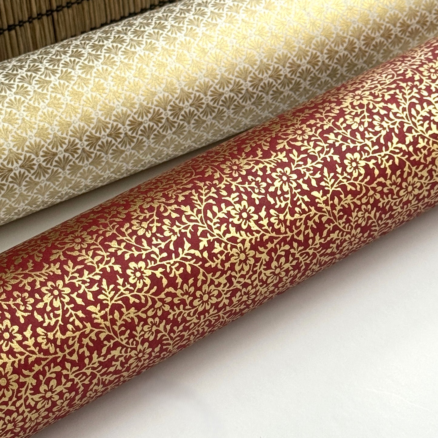 a sheet of Japanese chiyogami yuzen paper with a ditsy gold floral design on a deep red