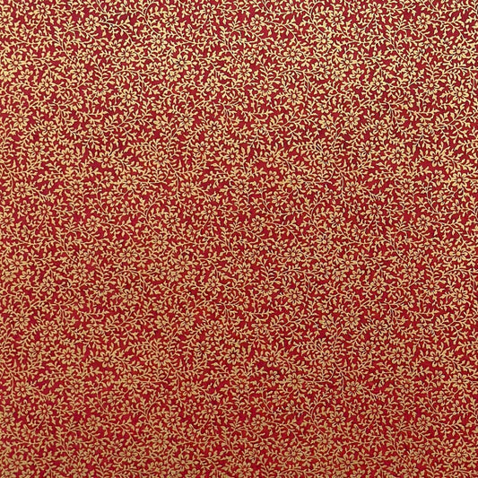 a sheet of Japanese chiyogami yuzen paper with a ditsy gold floral design on a deep red
