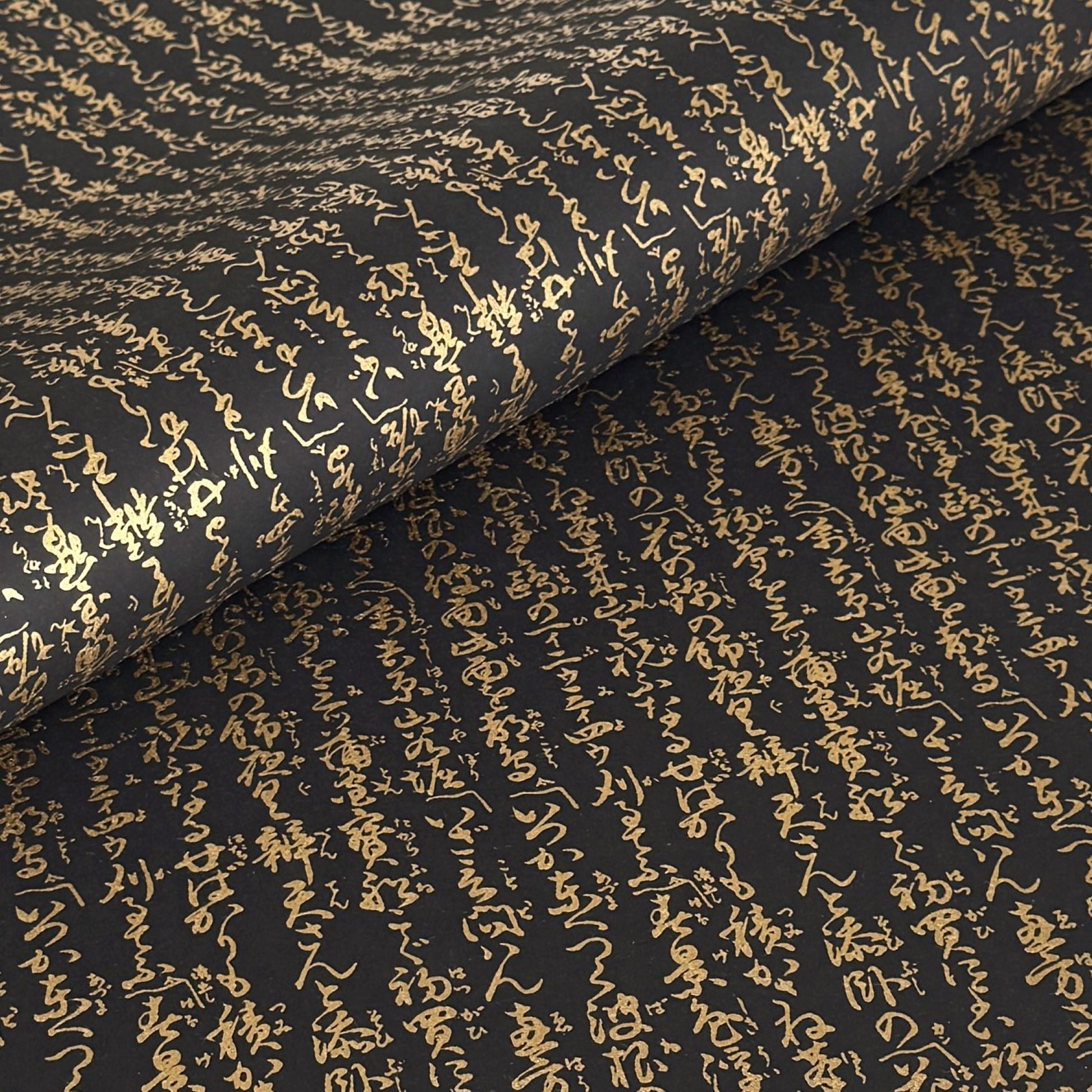 a sheet of Japanese chiyogami paper with gold Japanese kanji text on black background