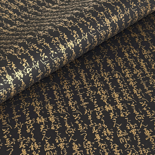 a sheet of Japanese chiyogami paper with gold Japanese kanji text on black background