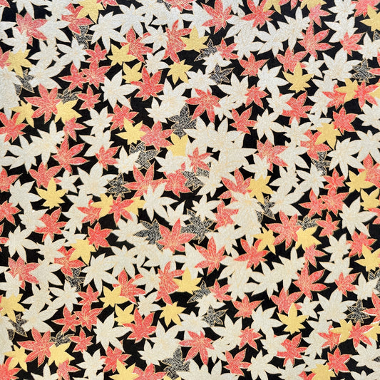 Japanese silkscreen chiyogami paper with an abundance of falling maple leaves in red, gold and silver on black backdrop