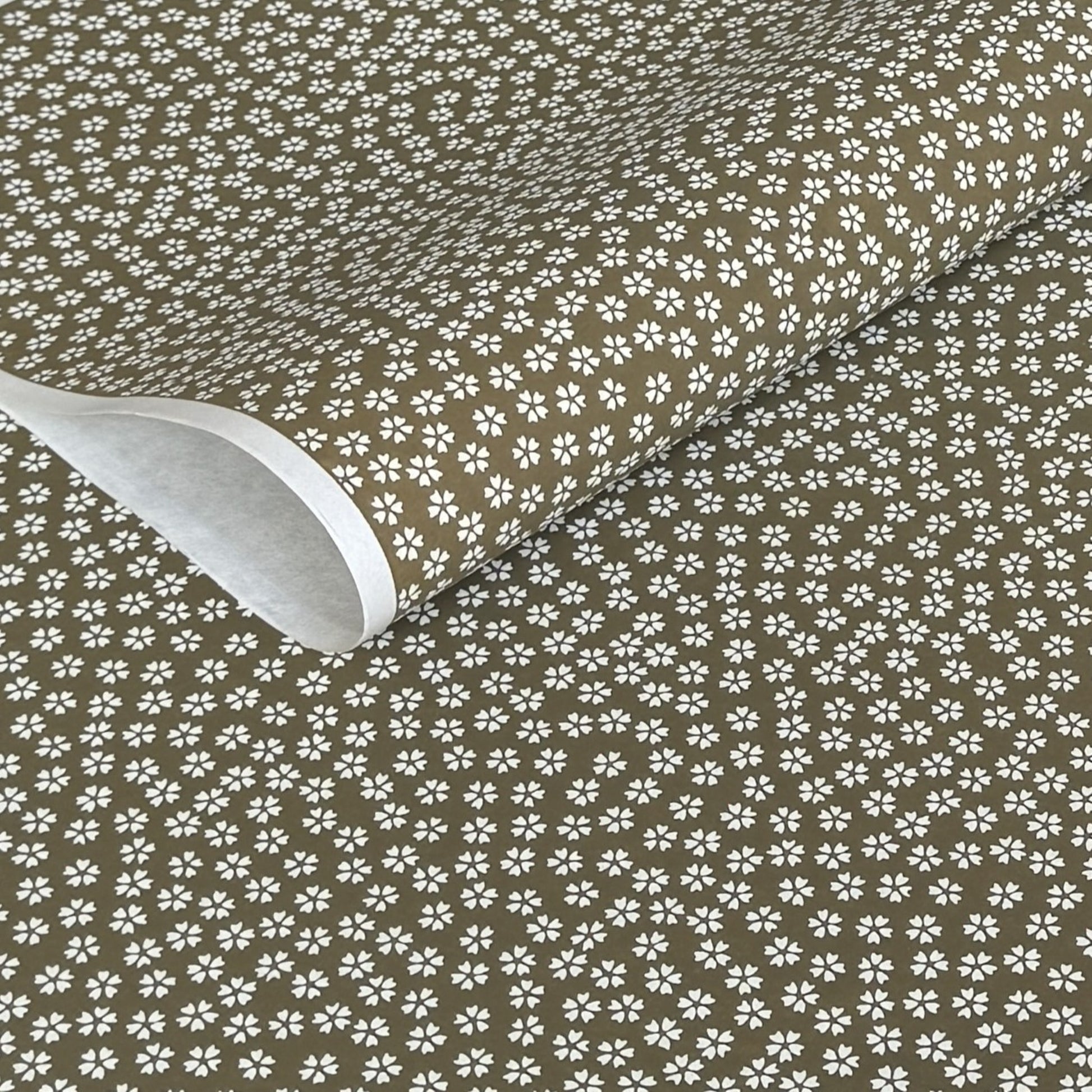 a sheet of chiyogami paper with a mocha brown background and little white stylised cherry blossom flowers