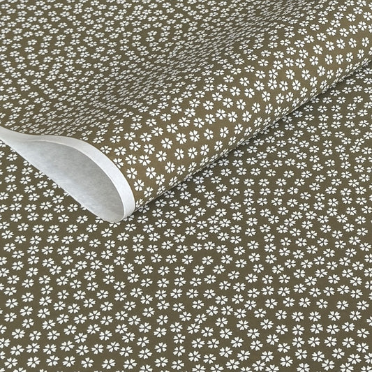 a sheet of chiyogami paper with a mocha brown background and little white stylised cherry blossom flowers
