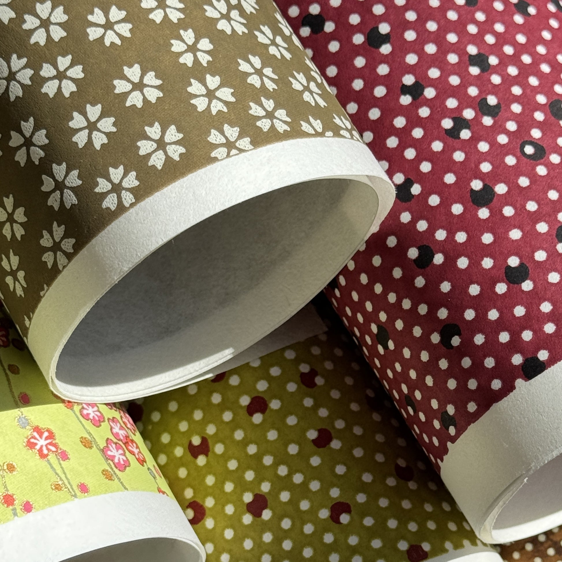 a sheet of chiyogami paper with a mocha brown background and little white stylised cherry blossom flowers