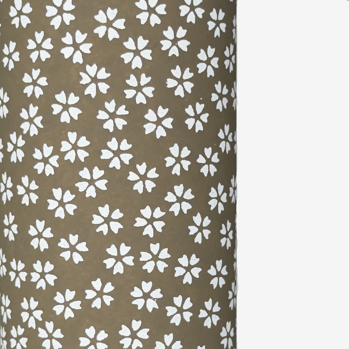 a sheet of chiyogami paper with a mocha brown background and little white stylised cherry blossom flowers