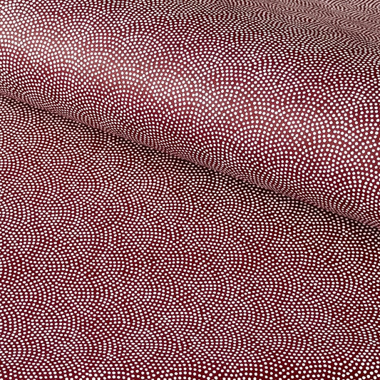 a sheet of Japanese chiyogami paper with an aubergine background and a small repeat pattern of tiny white dots in an arch shape